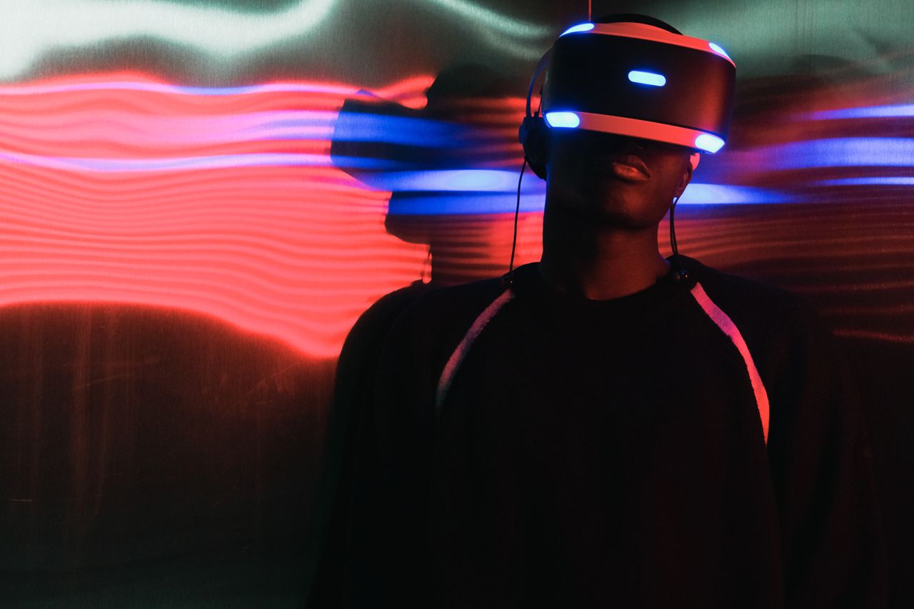 Mastering the First Impression: Your intriguing post title goes here A person wearing virtual reality headset surrounded by colorful neon lights, enjoying a digital world.