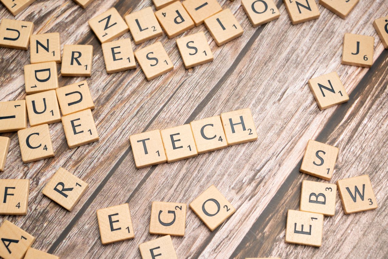The Art of Drawing Readers In: Your attractive post title goes here Wooden Scrabble tiles spelling TECH on a textured surface, showcasing creativity.